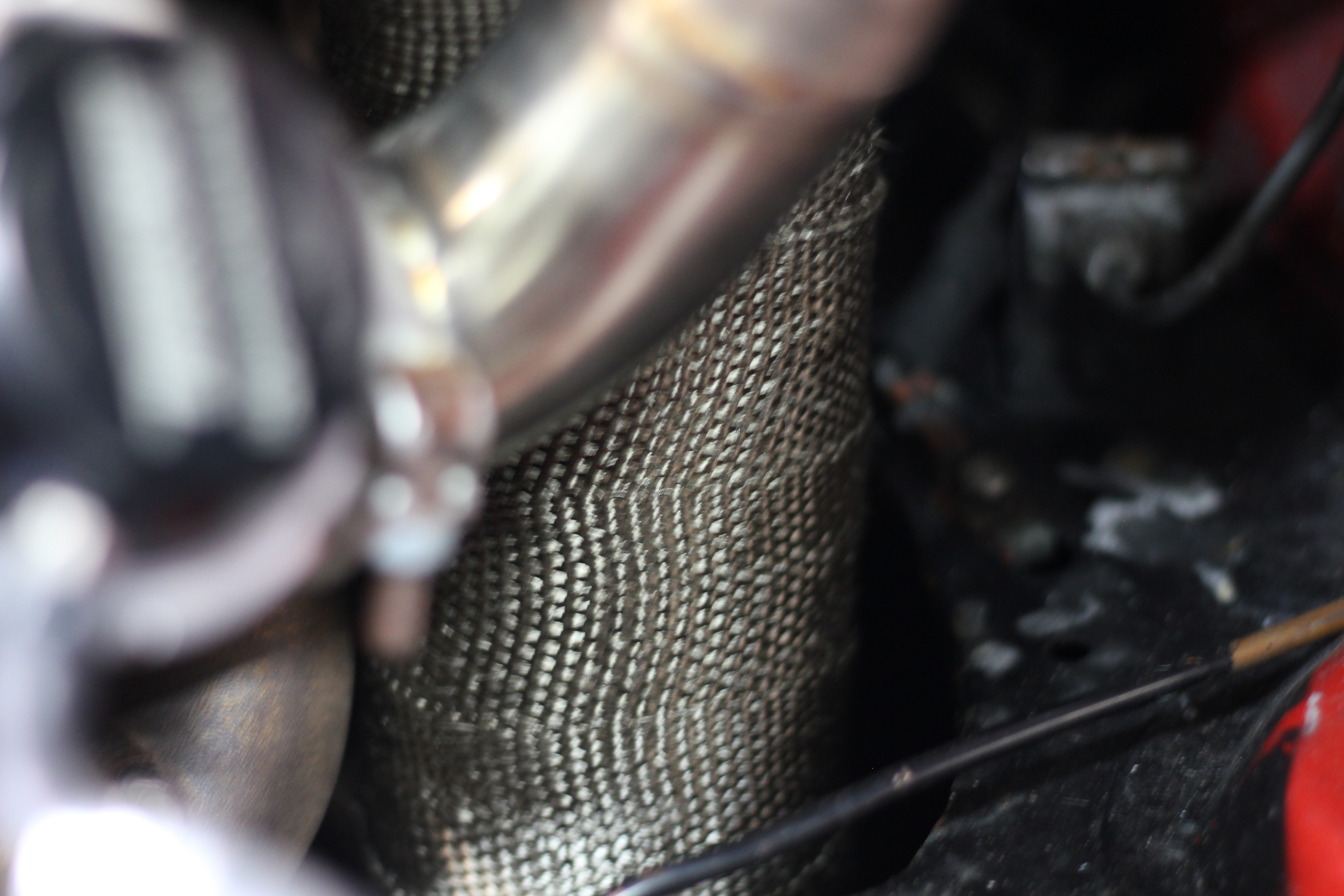 Tom's MX-5 downpipe wrapped to help reduce tunnel and cabin heat